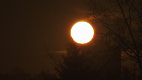 sun rising up slowly shining through clouds at dawn - static shot