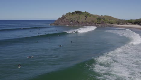 people surfing at cabarita beach with norries headland in nsw, australia - aerial drone shot