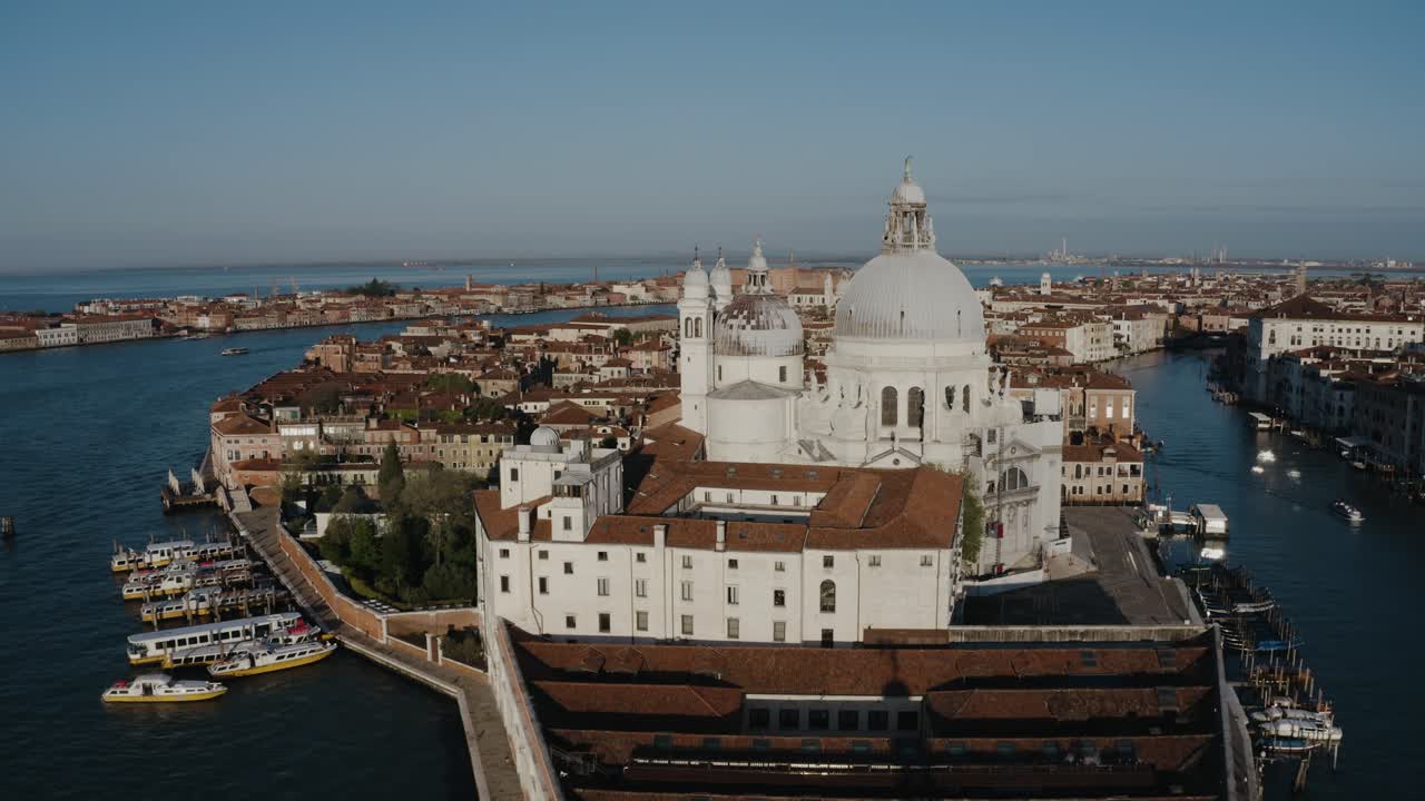 Aerial view flying over Punta della Dogana and Basilica di Santa Maria della Salute in Venice, Italy