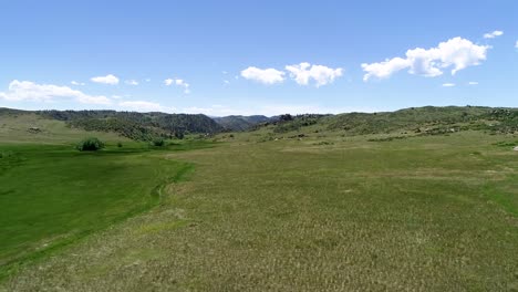 Grand-Foothills-Vista-Überflug-Von-Einer-Drohne-Mit-Wunderschönem-Blauen-Himmel-Und-Bauschigen-Wolken-über-Einer-Tiefen,-Malerischen-Landschaft