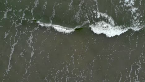 Aerial-shot-of-waves-crashing-into-sandy-beach-of-Ustka-in-winter