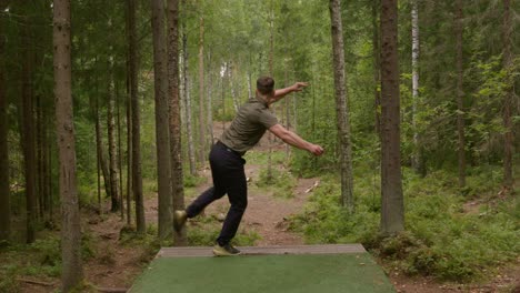 golfista de disco lanza un tiro de apertura de revés desde el tee