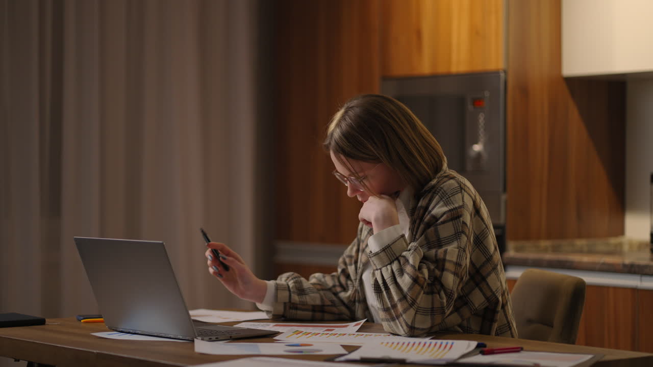 pretty student woman sit at home looking at computer screen makes assignment e-learning on laptop. Telecommuting remote job new software learning modern tech usage concept