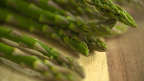 a bunch of fresh, green asparagus sitting on a wooden cutting board