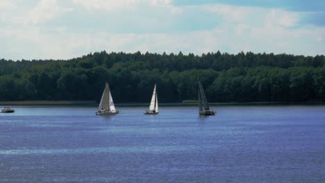 tourist sailing on yachts on calm lake of charzykowy in northern poland