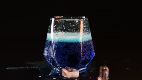 bebida azul efervescente en un vaso de vidrio