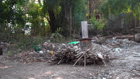 pilas de compost de basura y madera con barriles de quema en el bosque en tierras de cultivo en chiang mai, tailandia