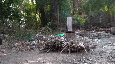 garbage compost and wood piles with burn barrel in forest on farmland in chiang mai thailand