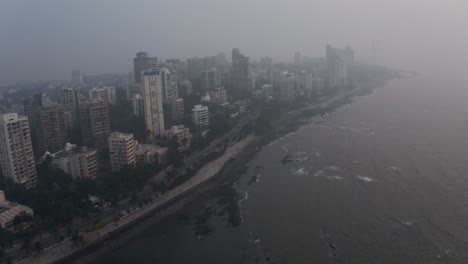 rotating drone shot of mumbai coastline on a hazy day high tide