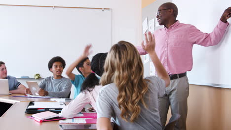 Alumna-De-Secundaria-Escribiendo-En-Una-Pizarra-En-Clase-De-Matemáticas