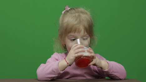 Girl-sitting-at-the-table-and-drinks-yogurt-milk.-Funny-milk-mustache