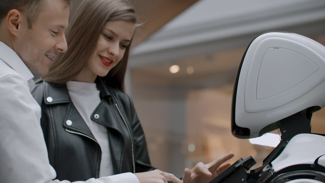 un hombre y una mujer se comunican con una persona cibernética sonriendo y riendo. robot droide interactúa con los humanos