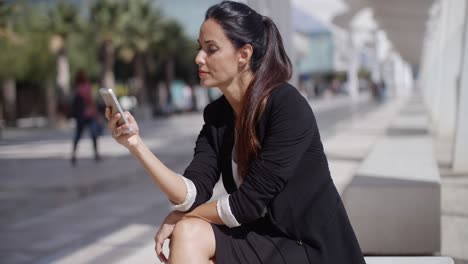 elegant businesswoman checking her phone messages