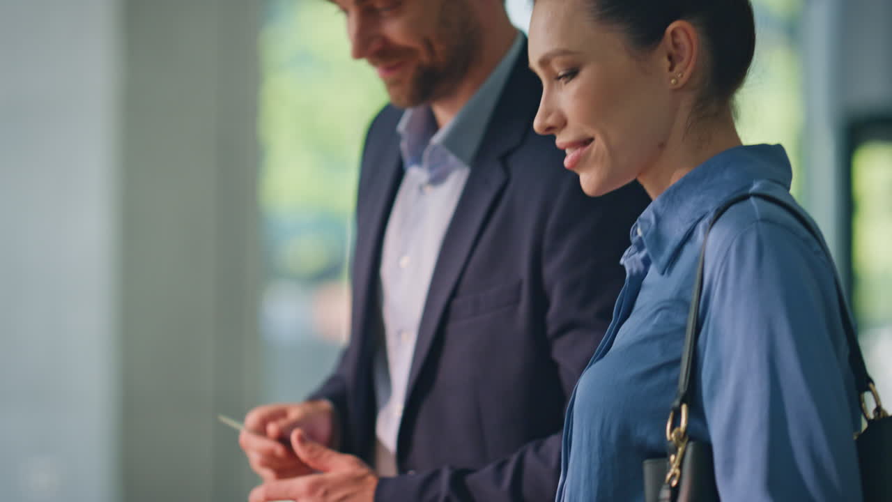 Hands making cashless payment with smartphone. Smiling clients check in hotel