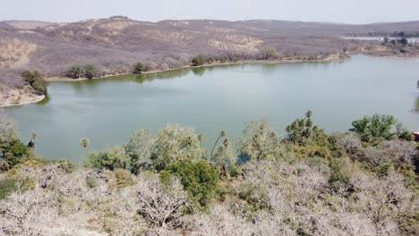 Tiro-De-Seguimiento-A-Través-Del-Arco-Del-Fuerte-De-Ranthambore-Con-Vistas-Al-Lago-Ragbagh-En-El-Parque-Nacional-De-Ranthambore,-Rajasthan,-India