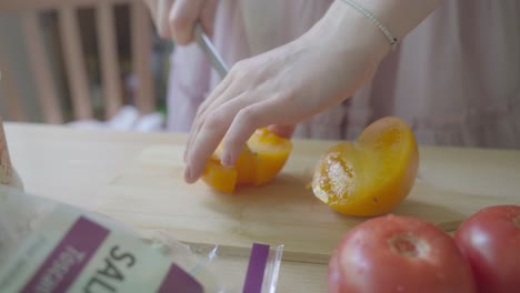 Messer-Schneidet-In-Die-Pralle,-Sonnengebräunte-Haut-Der-Reifen,-Gelben-Tomate