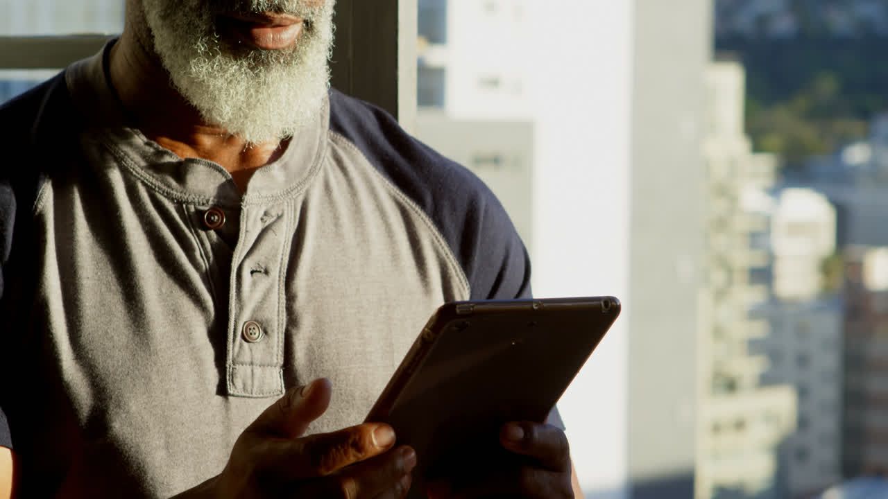 Senior man using digital tablet at home 4k