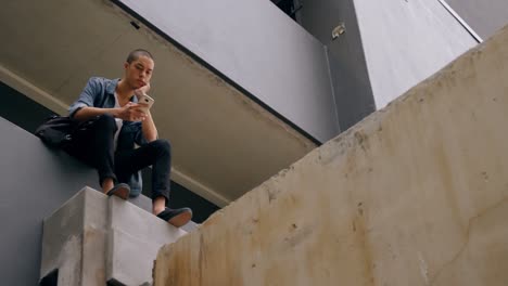 hombre usando teléfono móvil mientras está sentado en el corredor 4k