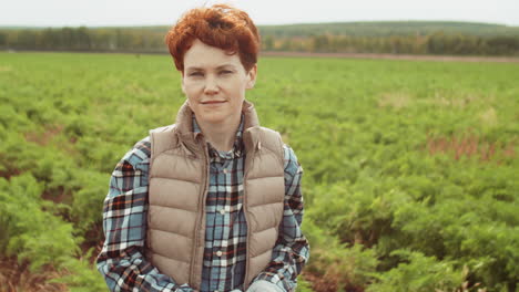 portrait of young redhead woman on farm field