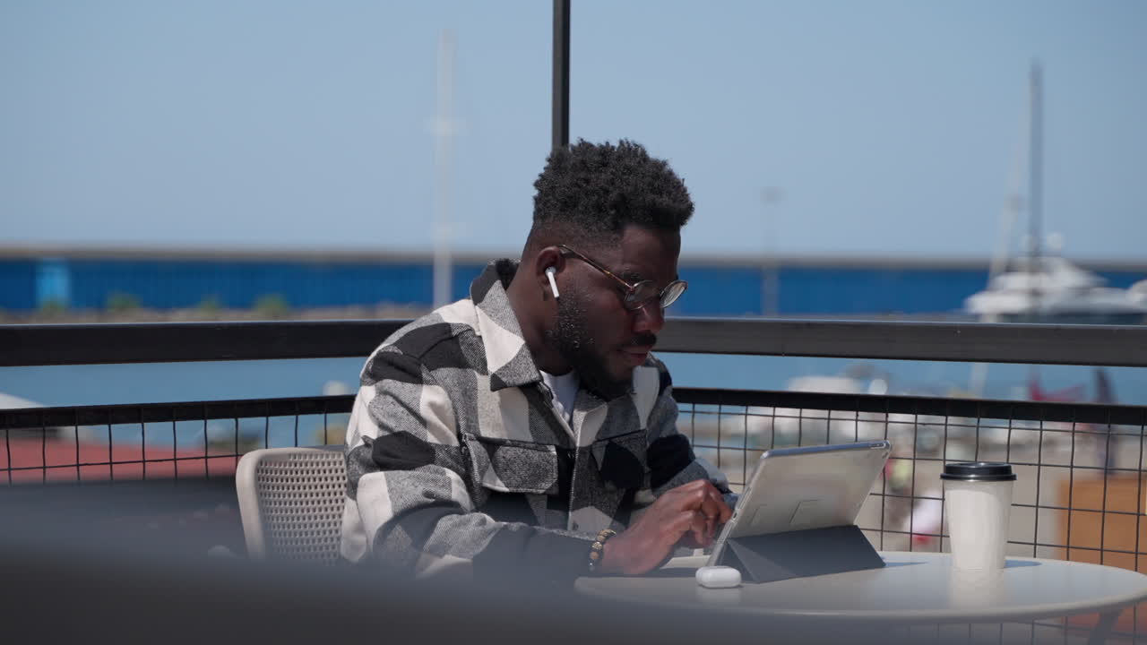 Man working on a tablet in a cafe