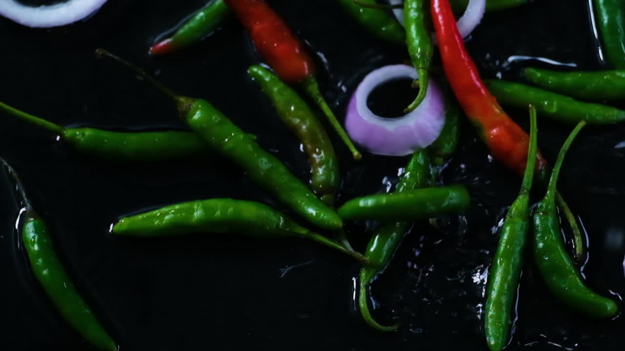 새로  ⁇ 은 녹색 칠리 페퍼와 물에 떨어지는  ⁇ 어낸 양파 반지