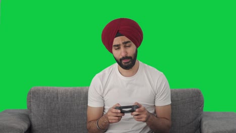 sleepy and tired sikh indian man playing video games green screen