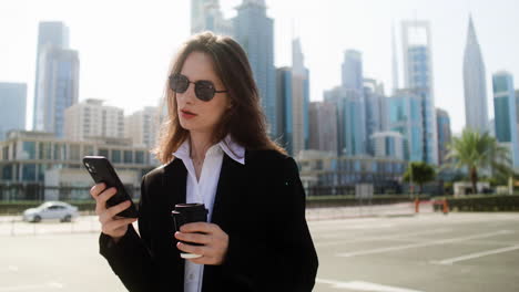 elegant businesswoman with phone outdoors