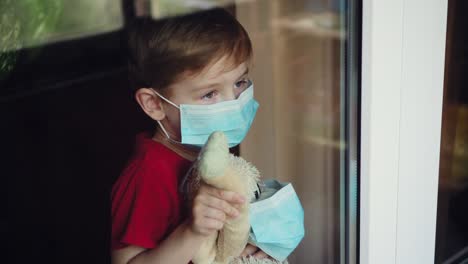 un niño con un juguete en una máscara salta por la ventana