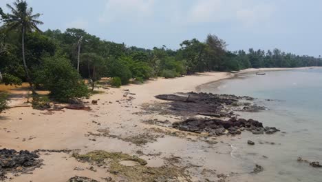 aerial view flying along empty ao kao beach in koh mak, thailand