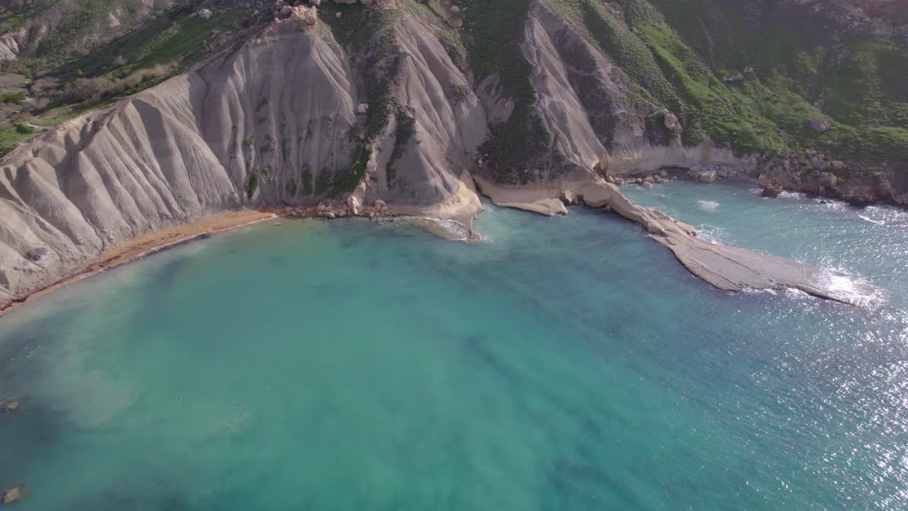 remota playa maltesa con aguas azules e impresionantes acantilados en una vista aérea