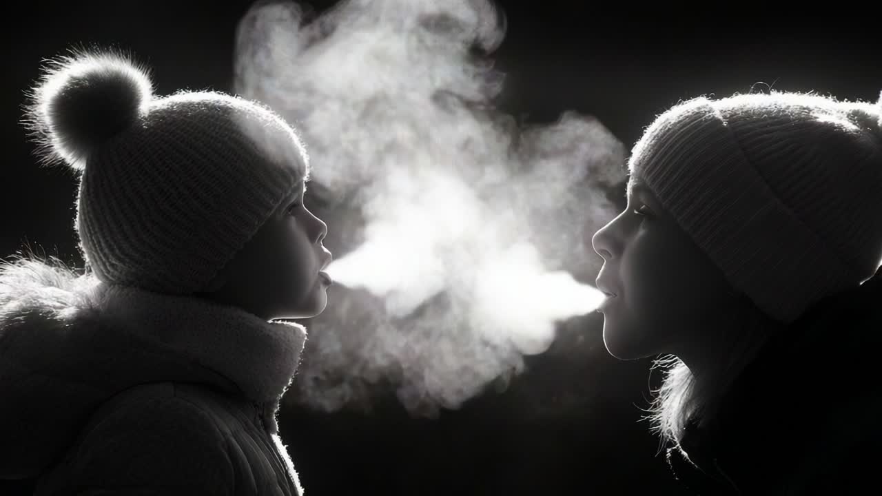 A heartwarming moment captured in monochrome as a child and an adult share a playful breath in the cold, their warm exhalations creating clouds of vapor in the frosty air