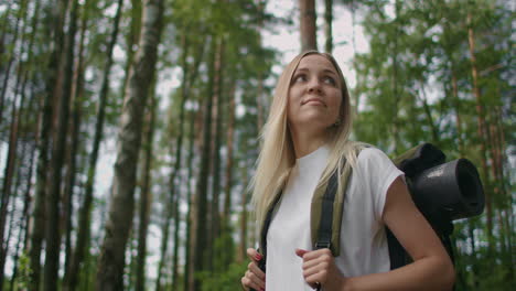 mujer explorando glade con helechos en el bosque. mujer de senderismo caminando en la selva de la selva. chica excursionista caminando con mochila a través de la densa naturaleza de la selva tropical