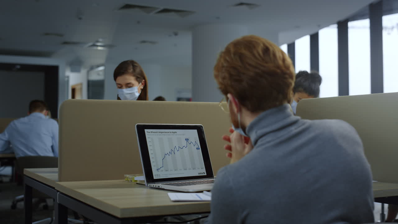 mujer de negocios con máscara médica trabajando en una computadora portátil. mujer mirando la pantalla de la computadora portátil