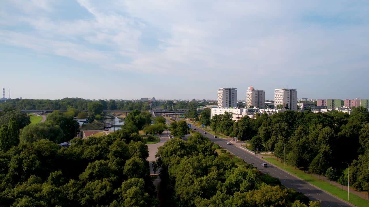 바르샤바 교외 지역의 강과 고속도로  ⁇ 에 있는 트리 애비뉴 위의 공중 전진 비행 - 배경에는 세 개의 고층 아파트 단지
