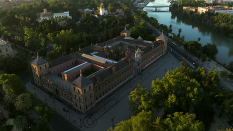 aerial view of palacio de san telmo, government building along the canal de alfonso xiii at sunrise in seville, spain