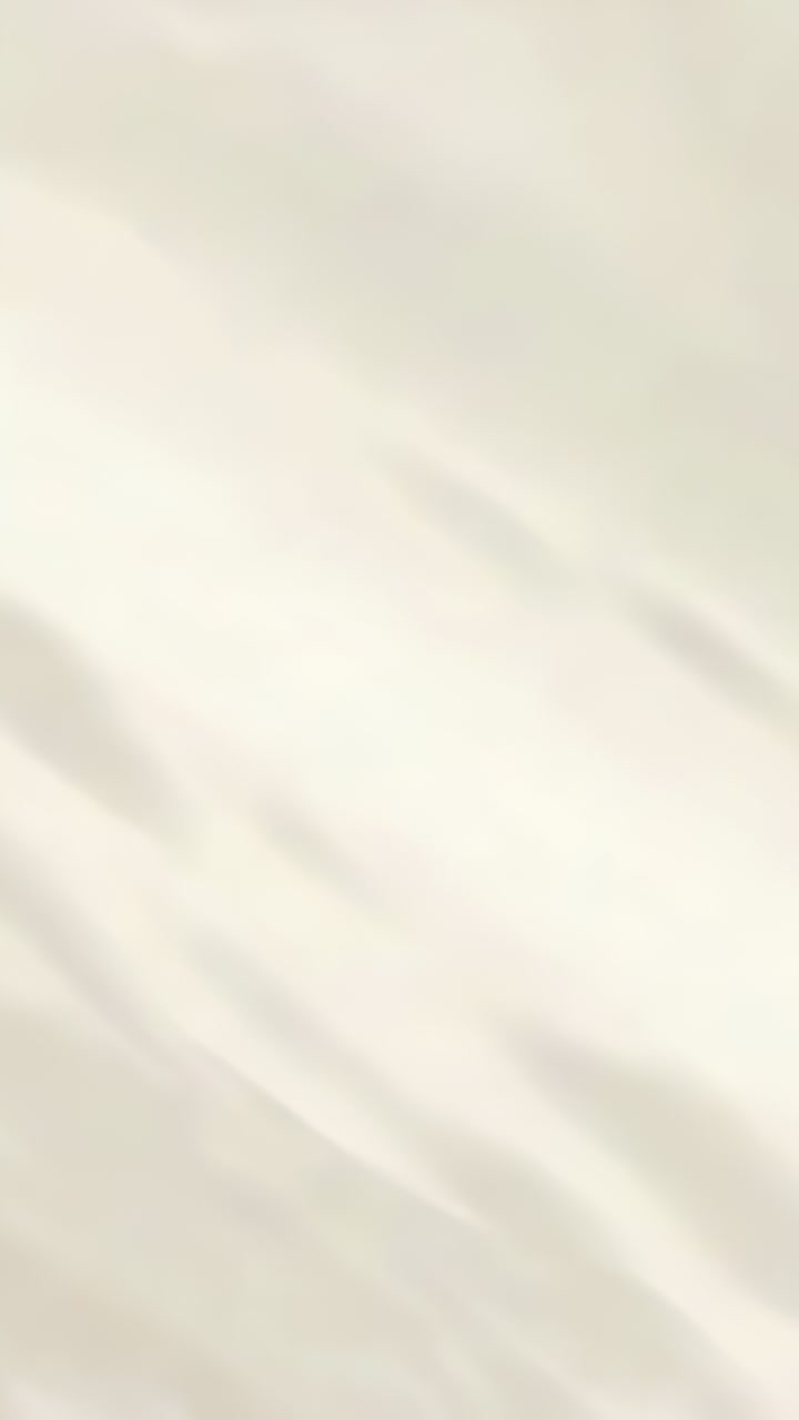 Video verticale: Luce soffusa che si sposta su un tessuto color crema chiaro a casa, mostrando bande d'ombra in movimento