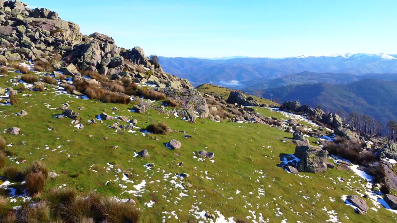 Mountain landscape with rocks, grass, and snow