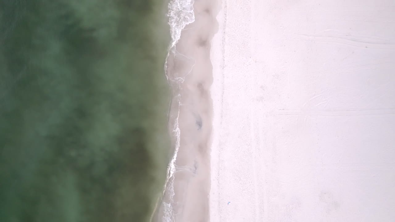 Sandy beach in Panama City Beach, Florida with drone video overhead looking down.