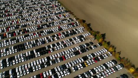 aerial footage of finished cars ready to be shipped on huge distribution center