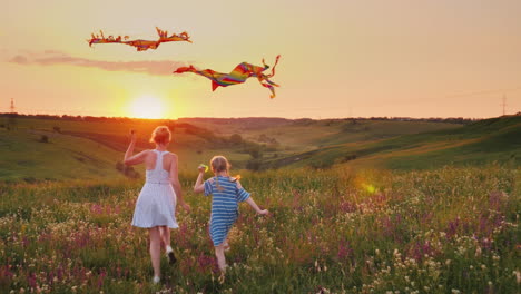 mom and daughter together launch kites in a picturesque place at sunset happy family concept 4k slow