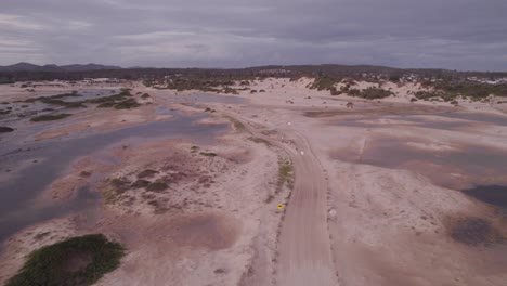 Fly-Over-Sweeping-Sand-Dune-Landscape-With-Lagoons-At-Stockton-Beach-In-New-South-Wales,-Australia