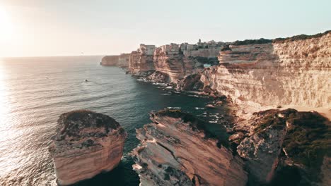 Bonifacio,-drone-flying-backwards-over-rocks,-cliffs,-Corsica