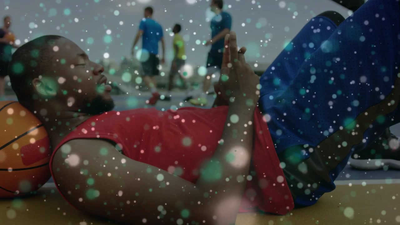 Athlete scrolling phone, resting on sports court with ball under head players passing drifting dots