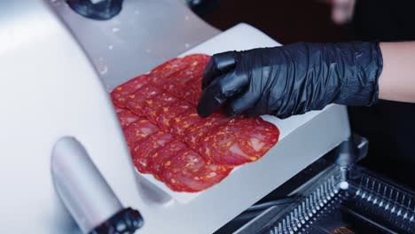 butcher cutting spanish chorizo in butcher's shop