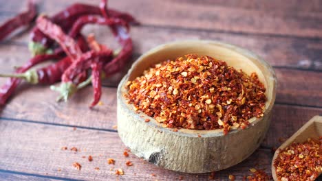 dried red chili flakes in wooden bowl