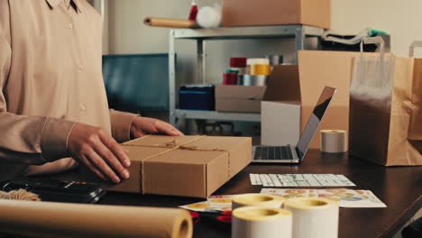 E-commerce storage shop, woman packing goods and clothes for second hand delivery market, dedicated Packaging and Shipping Workspace with Supplies and Technology for efficiency, online sales.