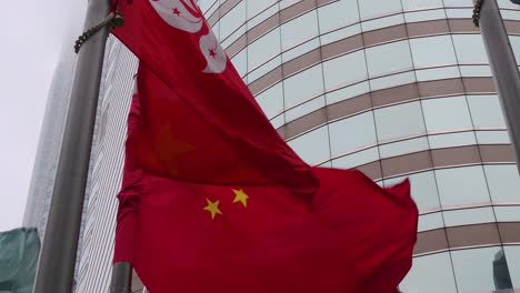 people's republic of china and the hong kong special administrative region flags are seen waving in the wind in hong kong