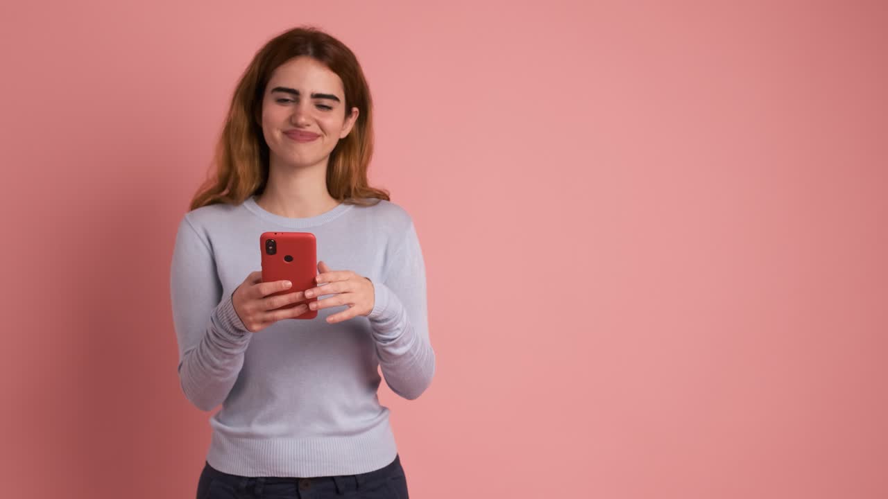Woman using mobile and pointing aside to a blank space