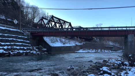 Puente-Ferroviario-Con-Corriente-En-La-Nieve-Del-Invierno