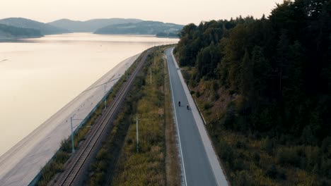 aerial view of motorcycle bikers riding stunning road next to the lake